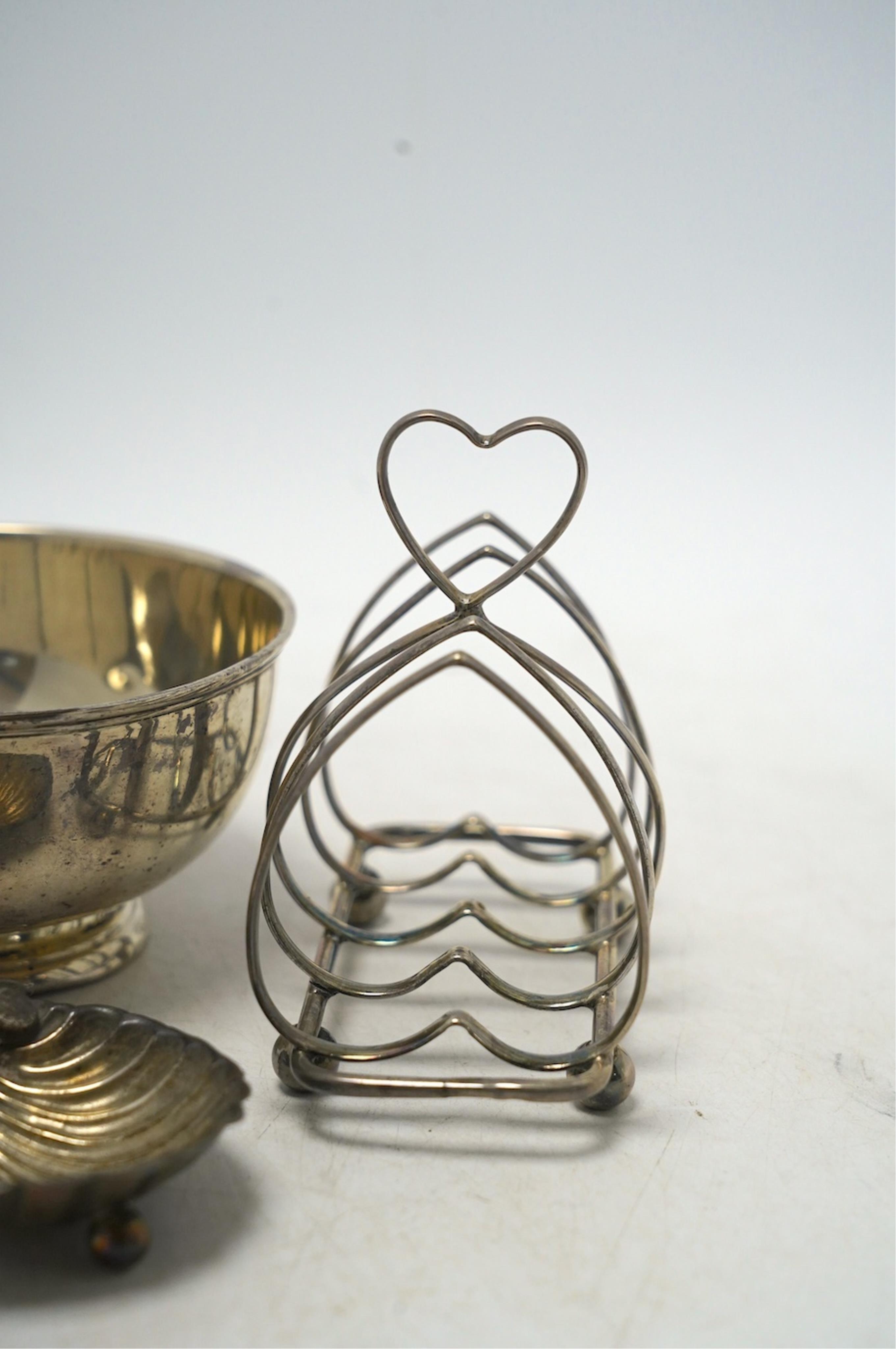 An Edwardian silver five bar toast rack, 96mm, together with a silver sugar bowl, a small silver dish and a silver shell salt, 8.3oz. Condition - fair